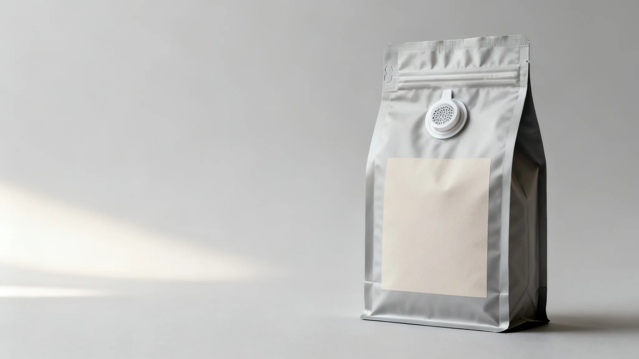 Custom printed matte coffee pouch with a one-way degassing valve on a blank front panel, neutral studio background